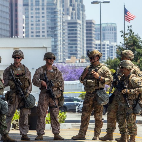 Two U.S. Marines (2nd, 3rd left) stand with California National Guard service members on June 13, 2025 in Los Angeles.
