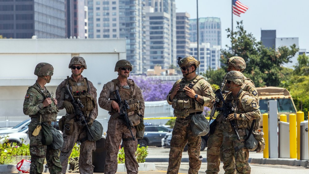 Two U.S. Marines (2nd, 3rd left) stand with California National Guard service members on June 13, 2025 in Los Angeles.