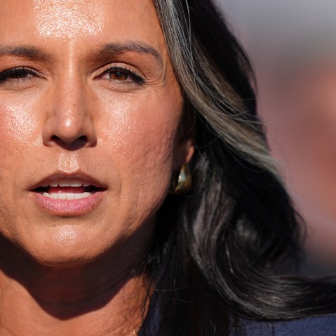 A closeup shot shows Tulsi Gabbard speaking outside.