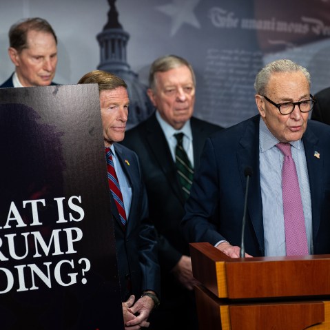 From left: Senator Ron Wyden, Senator Richard Blumenthal, Senator Dick Durbin, Senate Minority Leader Chuck Schumer, and Senator Jeff Merkley. On the left, a poster board that reads "WHAT IS TRUMP HIDING?"