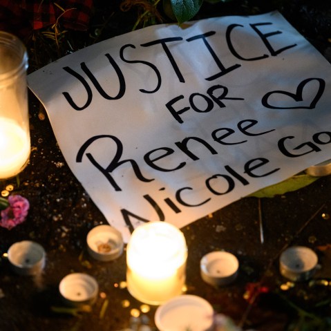 A sign reading "Justice for Renee Nicole Good" lays next to LED candles during a protest.