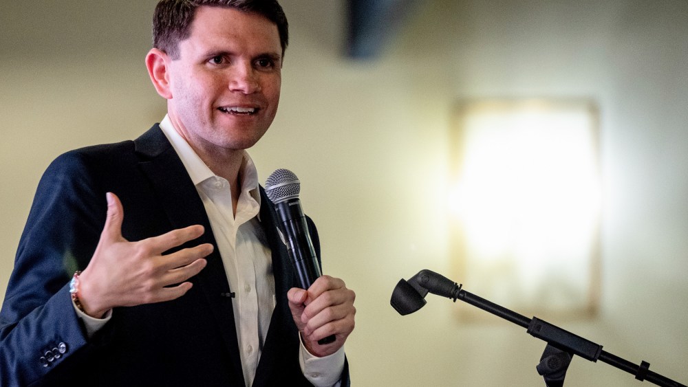 James Talarico speaks while holding a microphone.