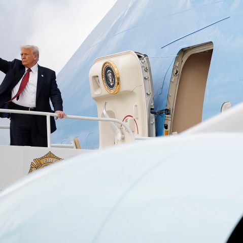 Donald Trump waves on the top step leading into Air Force One.