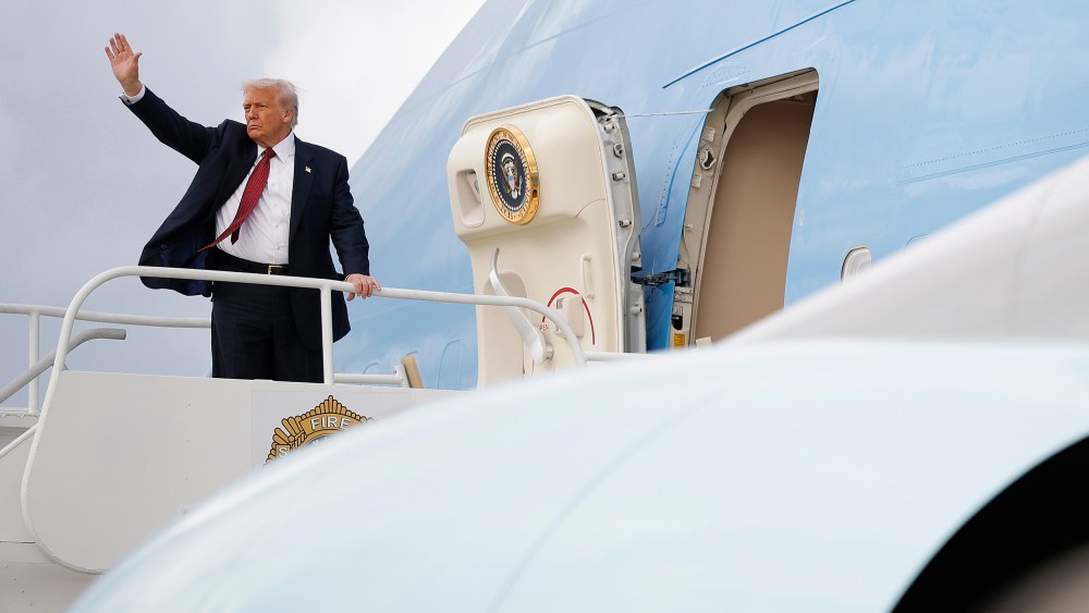 Donald Trump waves on the top step leading into Air Force One.