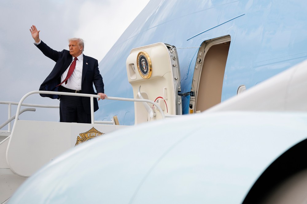 Donald Trump waves on the top step leading into Air Force One.