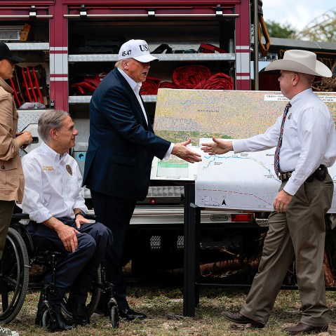 Donald Trump shakes hands with an official at the disaster scene after the deadly flooding in the area.