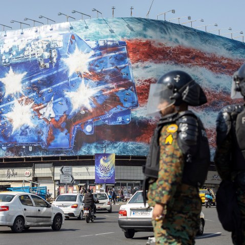 Twon officers stand in the street while a big billboard is seen in the background.