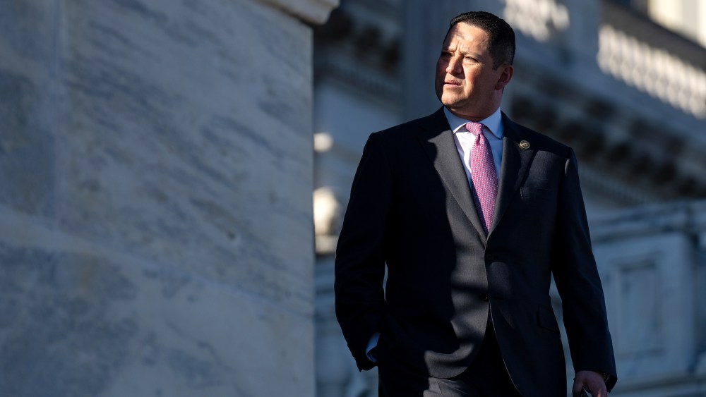 Tony Gonzales looks away as he walks down the steps where a small part of his face is in shade.