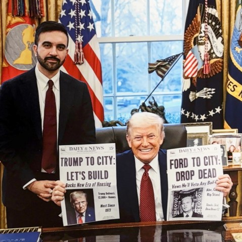 Donald Trump holds two cover pages of Daily News one of which reads "Trump To City: Let's Build" about building affordable housing. This cover page is made up and given to Trump by Mamdani as a gift.