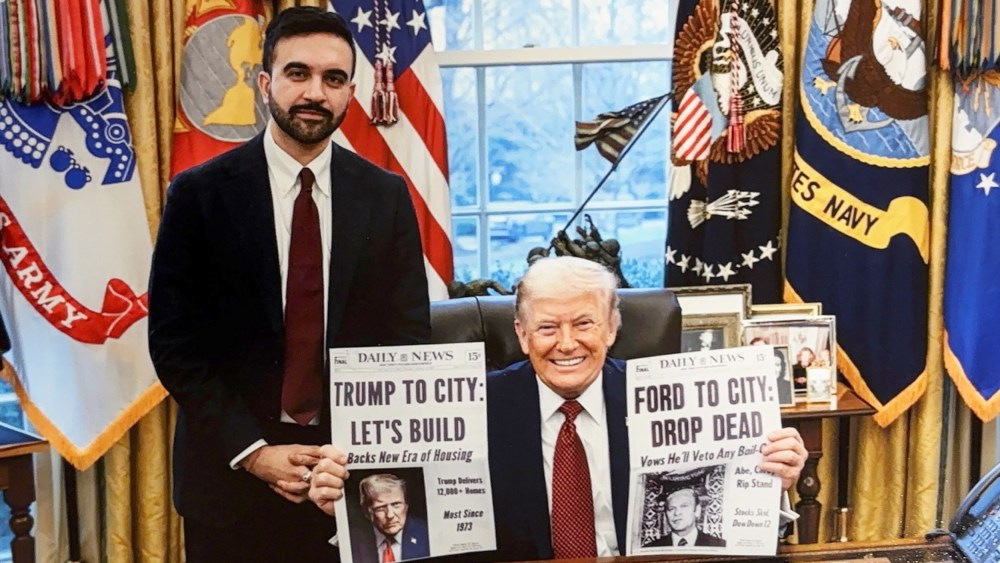 Donald Trump holds two cover pages of Daily News one of which reads "Trump To City: Let's Build" about building affordable housing. This cover page is made up and given to Trump by Mamdani as a gift.