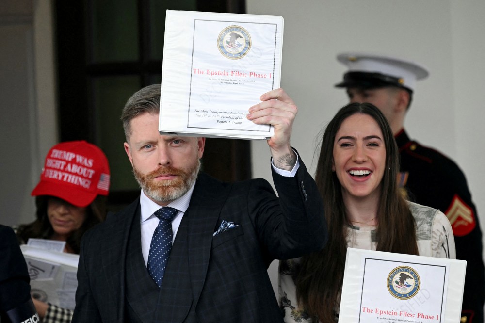 Three people cary Epstein binders, one of them is holdinhg it up.