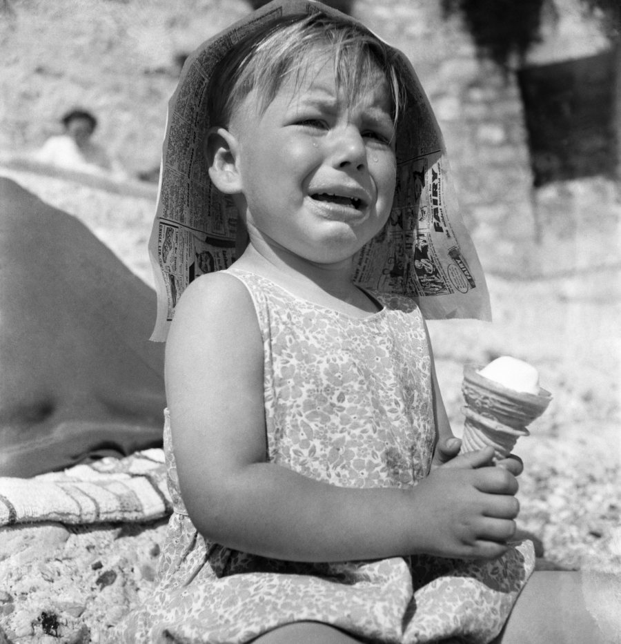 Three year old child crying on the shore at Plymouth after the sun melted an ice cream away. 