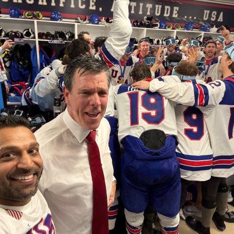 Kash Patel in a locker room with a group of men dressed for hockey are celebrating