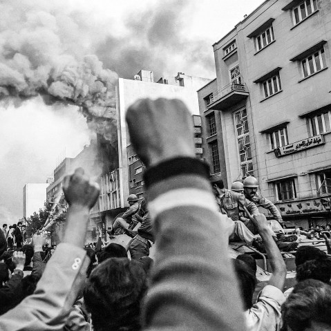 Troops loyal to Shah Mohammad Reza Pahlavi arrive to control a crowd of demonstrators outside a burning government building at the height of Islamic revolutionary fervor on Nov. 4 1978 in Tehran.