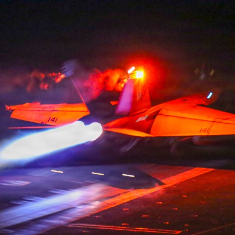 A fighter jet takes off at night.