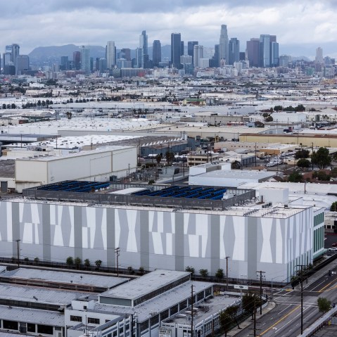 A data center is photographed from above with city skyline in the background.