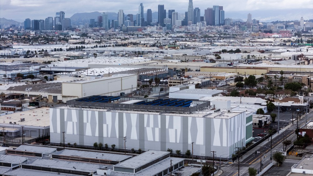 A data center is photographed from above with city skyline in the background.