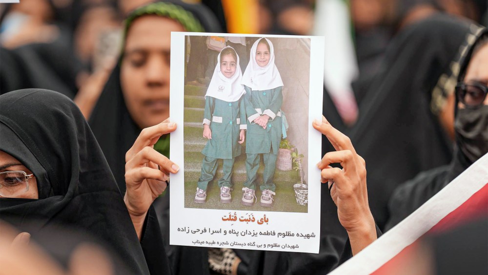 Mourners hold a portrait of a students during a funeral ceremony for children who were killed after a primary school was targeted in US and Israeli attacks in Minab, Iran.