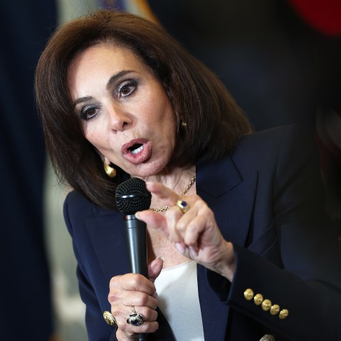 Jeanine Pirro holding a press conference, looking angry.