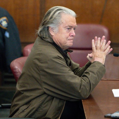 Steve Bannon sits at a desk.