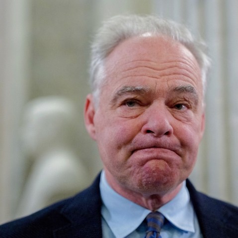 Tim Kaine looks in front of him with his lips pressed together.