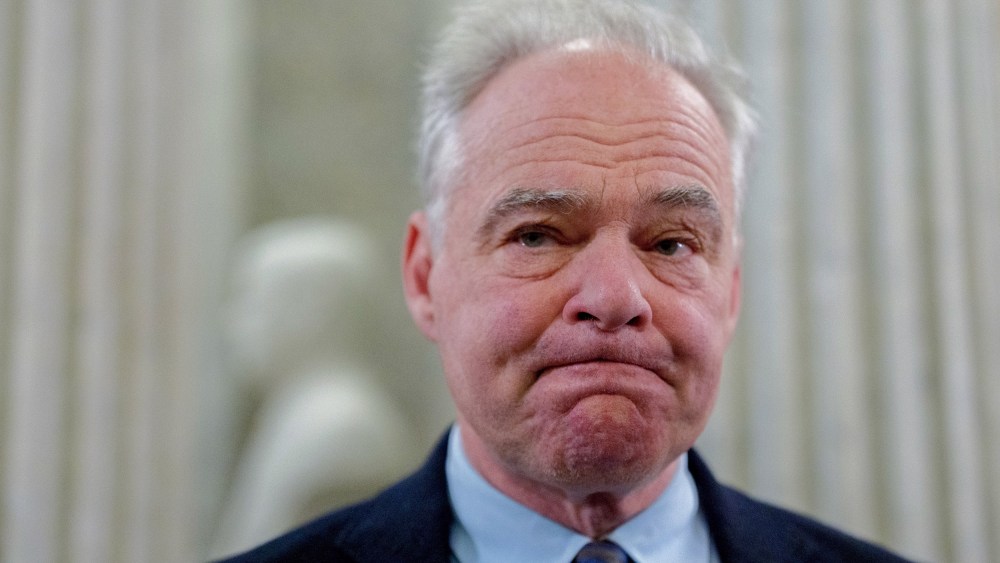 Tim Kaine looks in front of him with his lips pressed together.