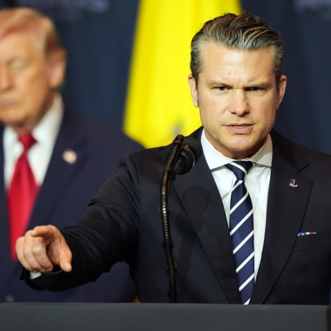 Defense Secretary Pete Hegseth speaks while President Donald Trump, left, listens.