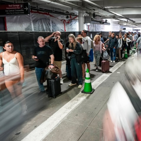 People wait in security check line in the parking garage.
