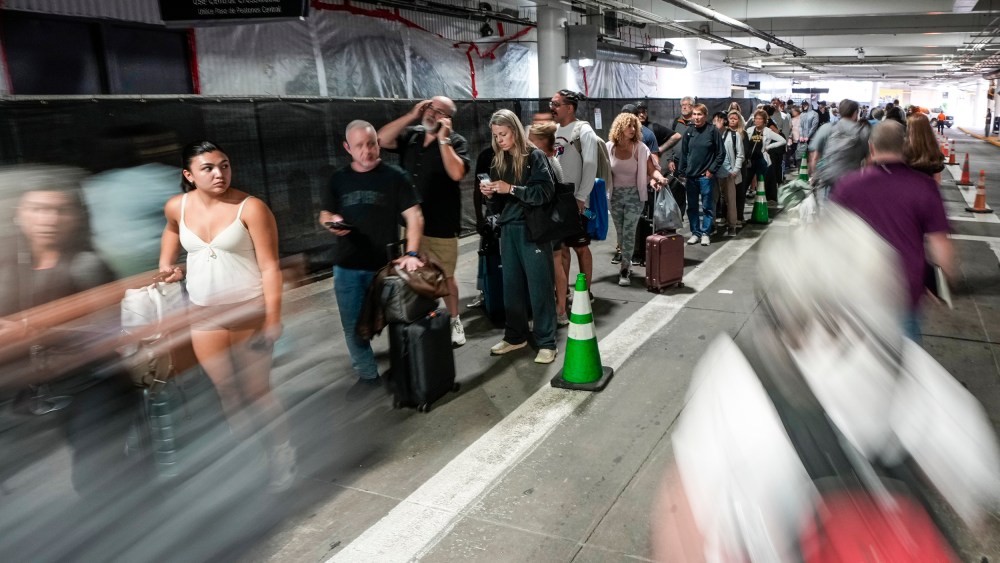 People wait in security check line in the parking garage.