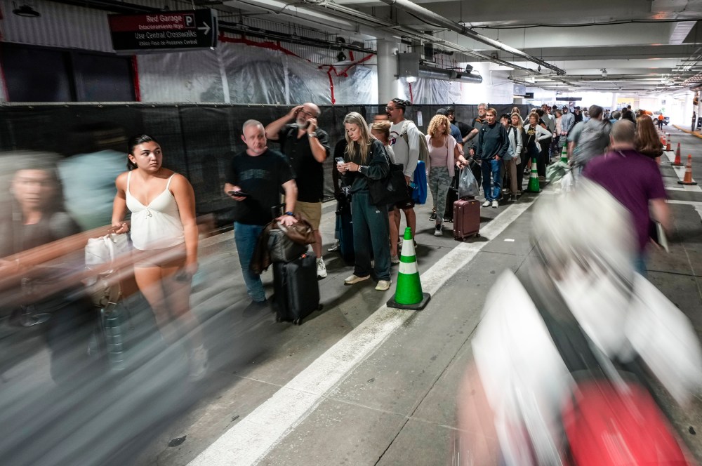 People wait in security check line in the parking garage.