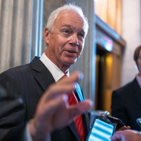 Ron Johnson surrounded by people holding their phones out to him.