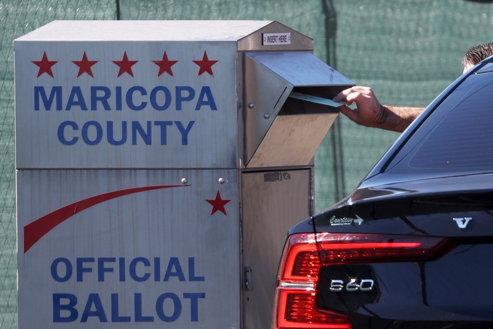 A voter drops their ballot into a drop box outside of the Maricopa County Tabulation and Election Center in Phoenix.
