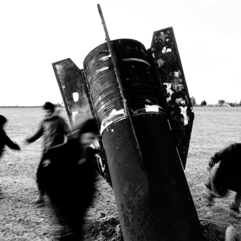 Children play around an unexploded missile that landed in an open field on the outskirts of Qamishli, eastern Syria, on March 5, 2026