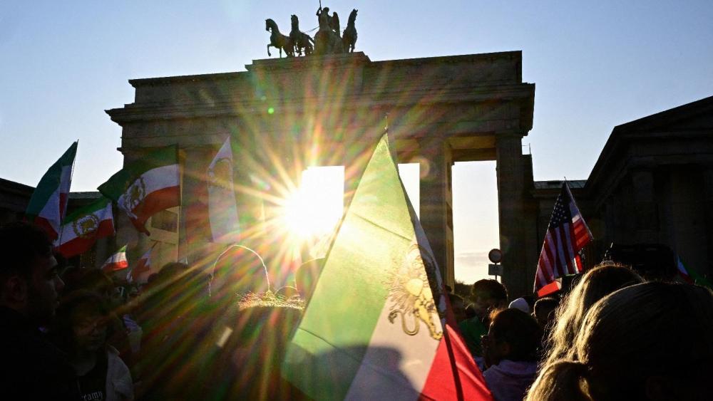 Protesters wave Iranian flags and shout slogans during a demonstration in Berlin, on Mar. 1, 2026.